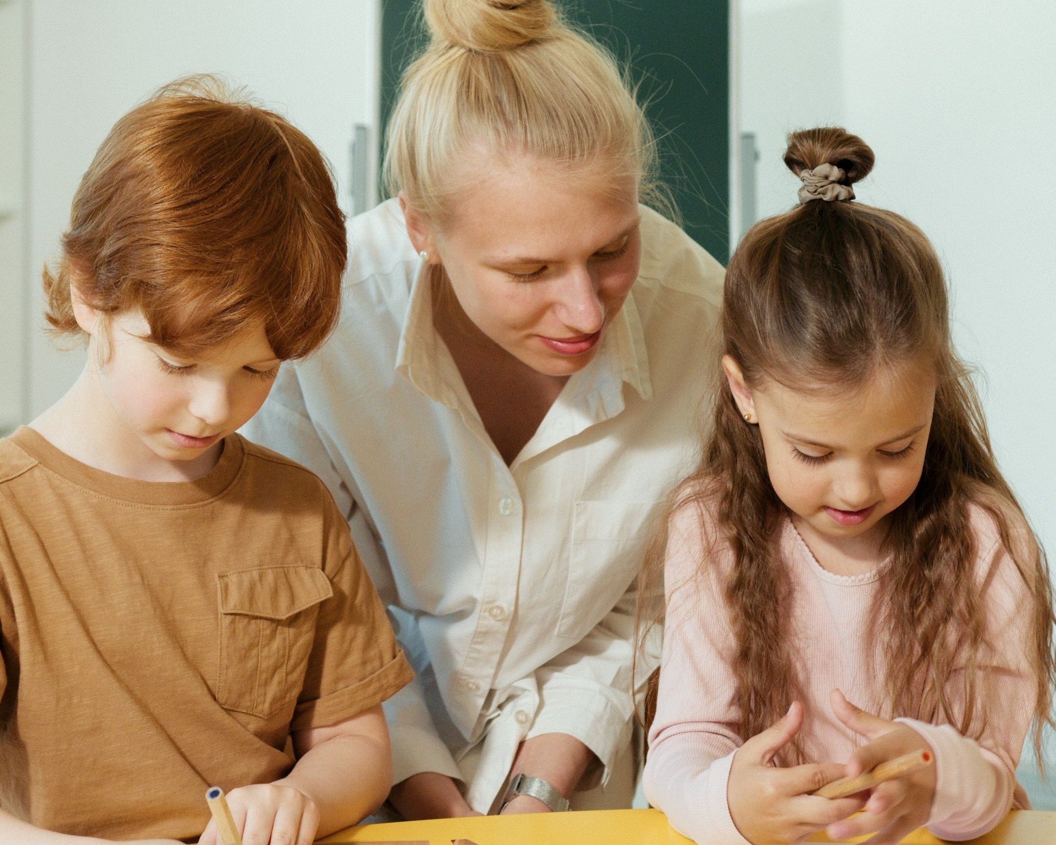 Erzieherin mit zwei Grundschulkindern